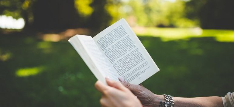 A person holding a book, best local movers in Boynton Beach