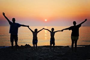 happy family holding hands on the beach to prepare children for relocation