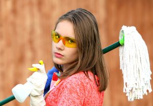a girl holding cleaning items