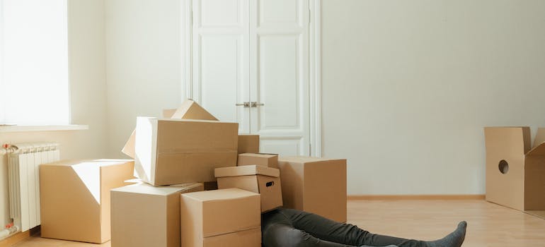 man on a floor with moving boxes