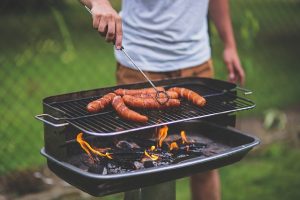 Man preparing sausages on a barbecue.