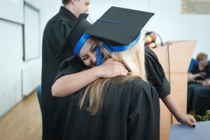 Two graduates hugging