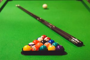 Pool table with balls and cues.