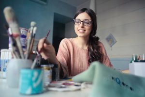 Girl artist paints in her room.