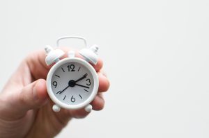 hand holding small clock