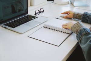 Planner and laptop on desk.