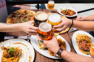 three hands holding beer glasses