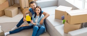 a happy couple surrounded by moving boxes