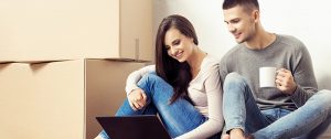 happy couple with laptop and boxes