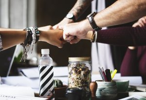 People in an office, fist bumping.