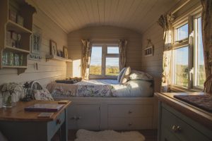 A room with a bed that has storage under it