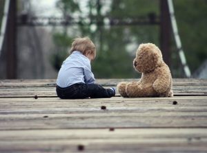 pack toys when moving- Baby boy playing with the plush bear