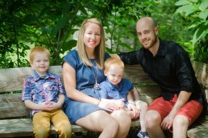 Mom, dad and their two boys enjoying some quality time on a park bench