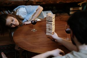 A couple enjoying a glass of wine and playing Jenga together