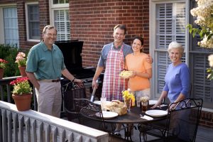 Two happy, neighborhood couples enjoying each other's company and a bit of barbecue.