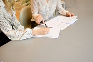 Two women signing moving documents