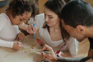 Mother and father helping their daughter with learning.