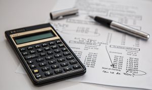 A budgeting equipment on a table weighting to be used for weighing up the pros and cons of living in Deerfield Beach.