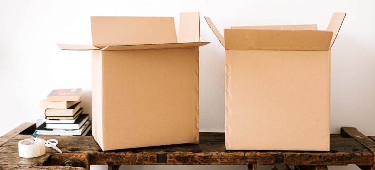 Carton boxes and stacked books on table that best local movers in Crestview can provide you with