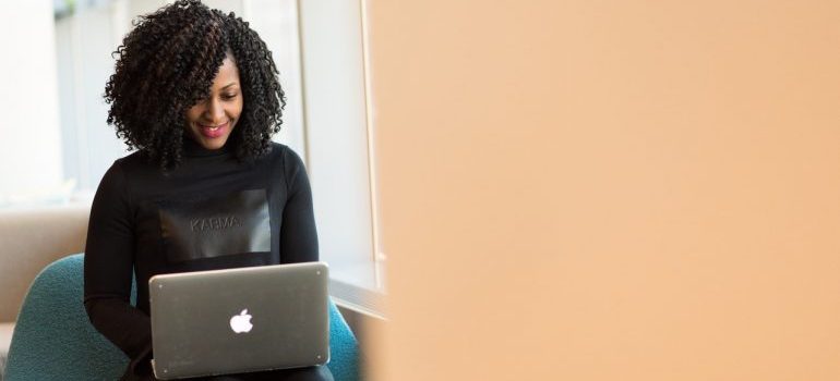 A woman smiling while using her laptop