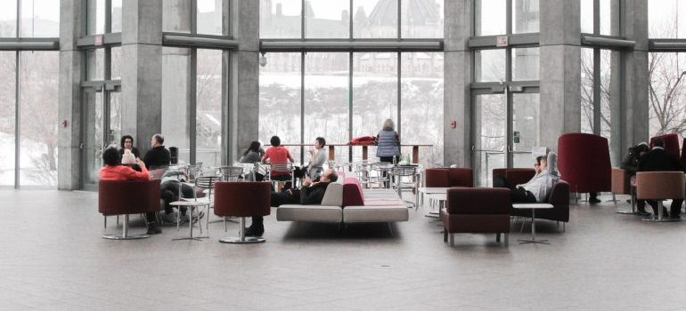 A large open office space with employees in red chairs, waiting for commercial movers Orlando has.