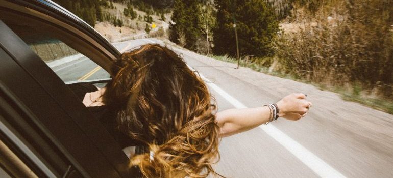 A woman enjoying the car ride.