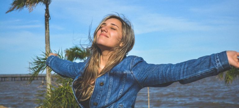 Woman with arms spread, enjoying after the relocation with residential movers Port St Lucie