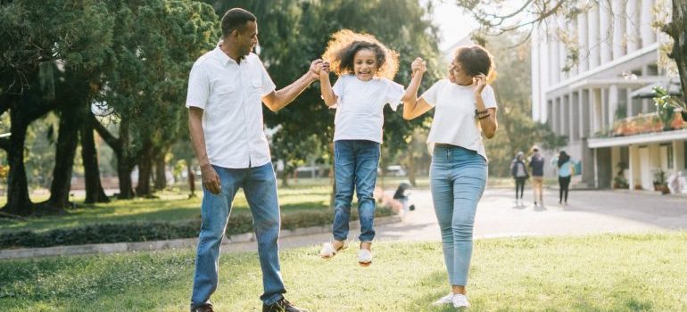 A mother and a father helping daughter jump.