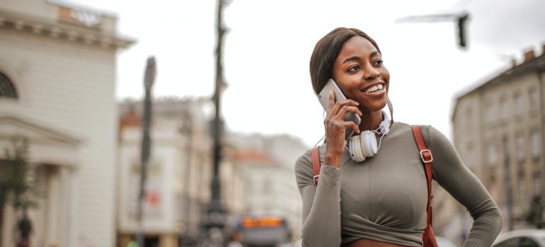 Smiling woman talking on the phone with residential movers Tallahassee FL.