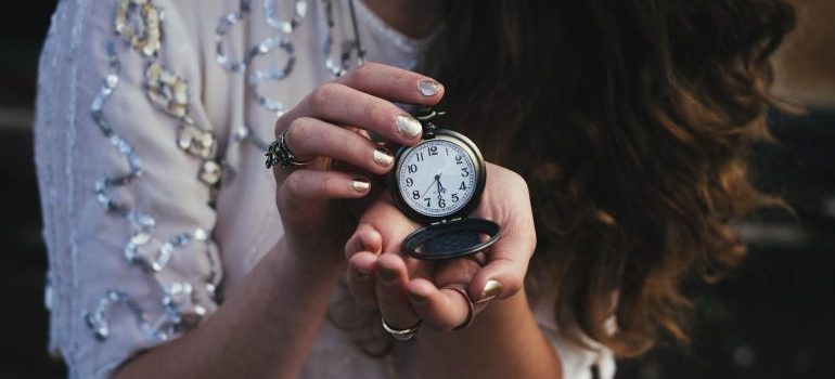 Woman holding pocket watch.