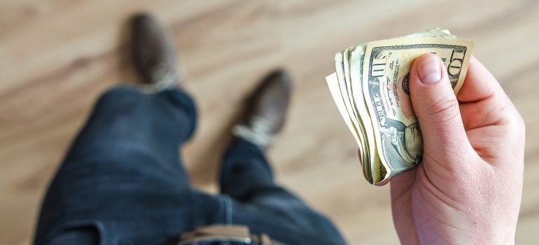 A person holding a stack of dollar bills.