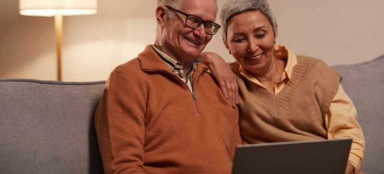 couple looking at recommendation for movers Aventura FL on their laptop