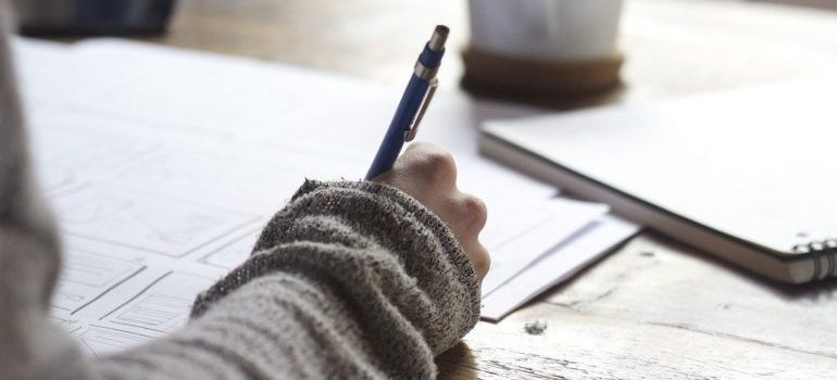 A woman holding a pen and writing.