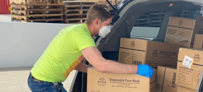 A man loading cardboard boxes in a van 