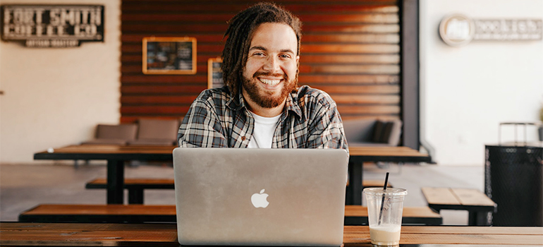 a happy man in front of computer