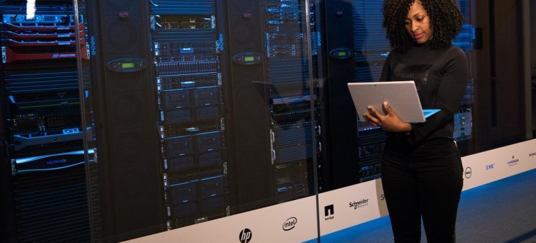 A woman with a laptop next to a system 