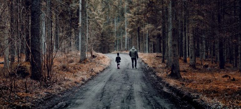 man and boy walking in the woods