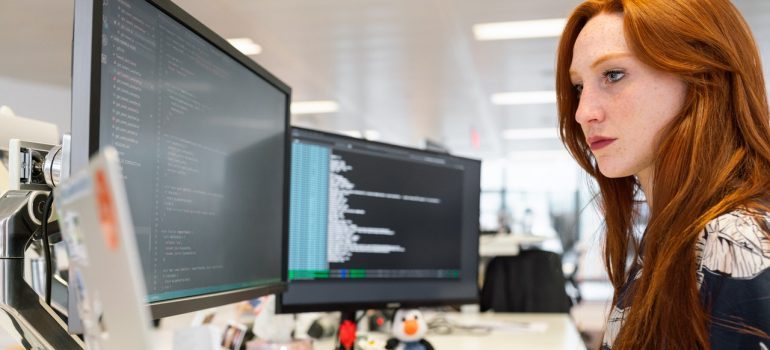 A redhead woman coding.