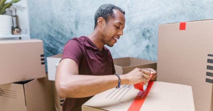 A person taping a moving box.