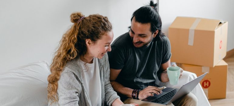 A couple laughing over on a laptop