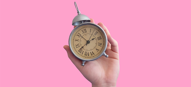 a hand holding a clock