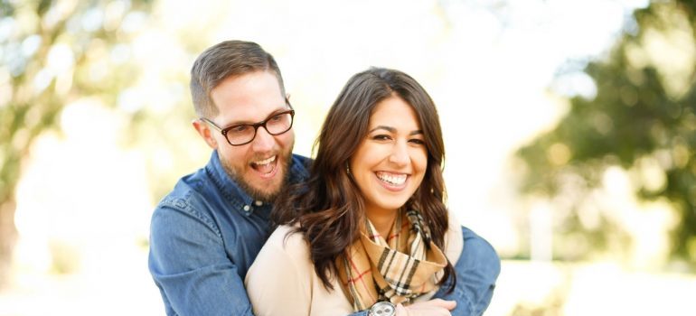 A smiling young couple hugging.