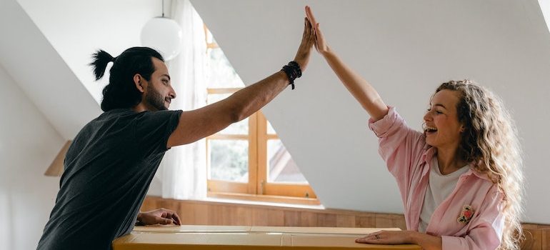 a couple high fiving over a box