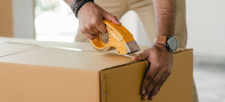 faceless man taping a box