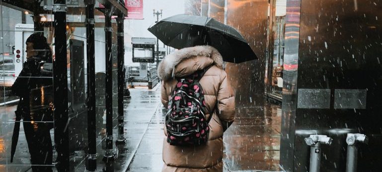 A woman moving in the rain since she didnt know how important it is to choose your moving date wisely.