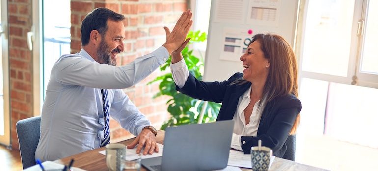 Man and woman in the office high fiving