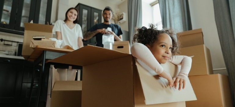 happy family watching their daughter in a moving box