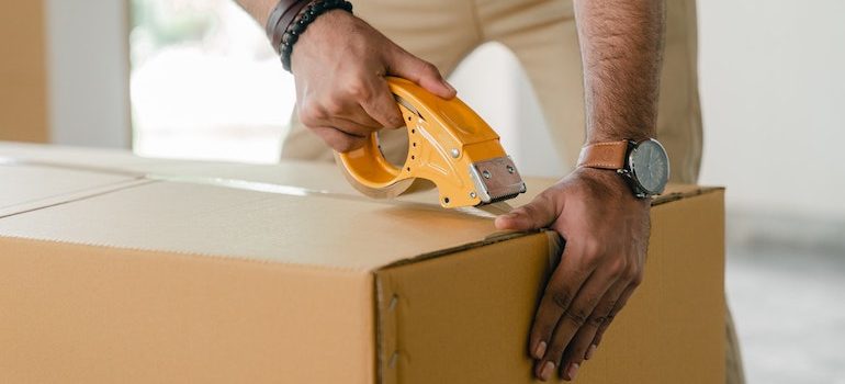 man taping a box