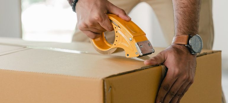 man sealing a box