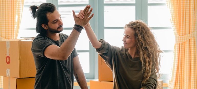 man and woman high fiving surounded by boxes